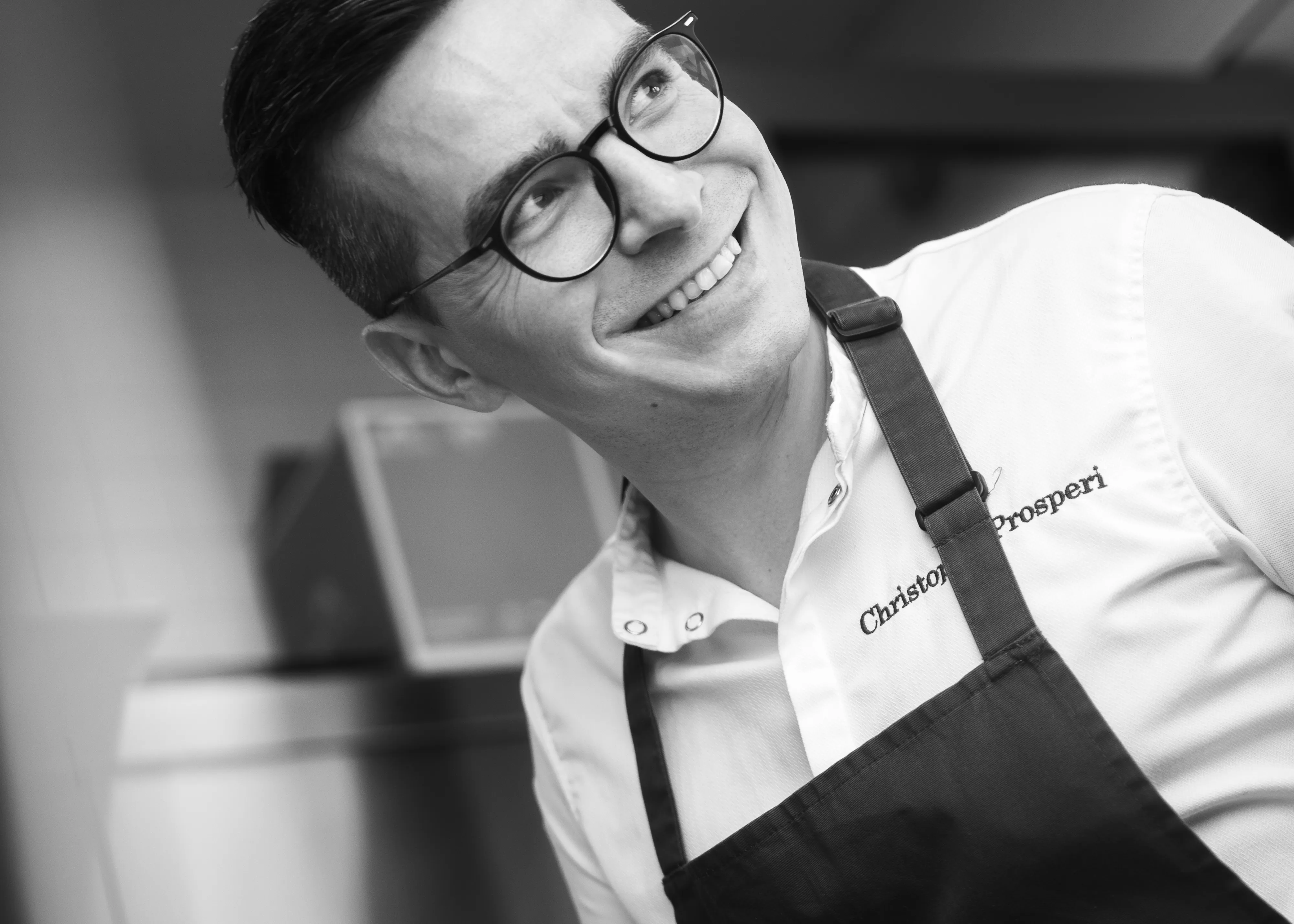 Christophe Prosperi laughing in the kitchen, black and white portrait
