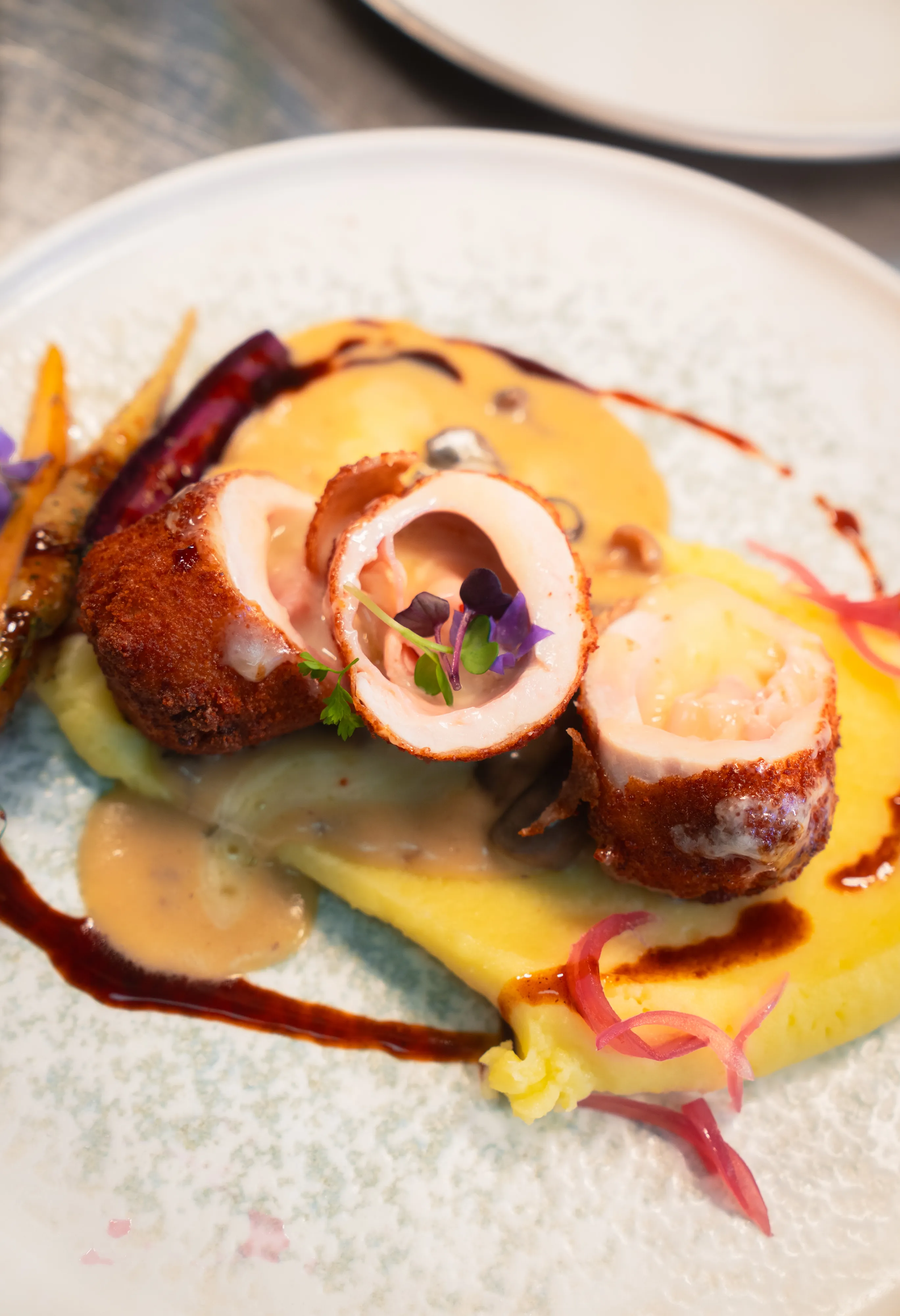 Crispy croquette with mashed potato and edible flowers