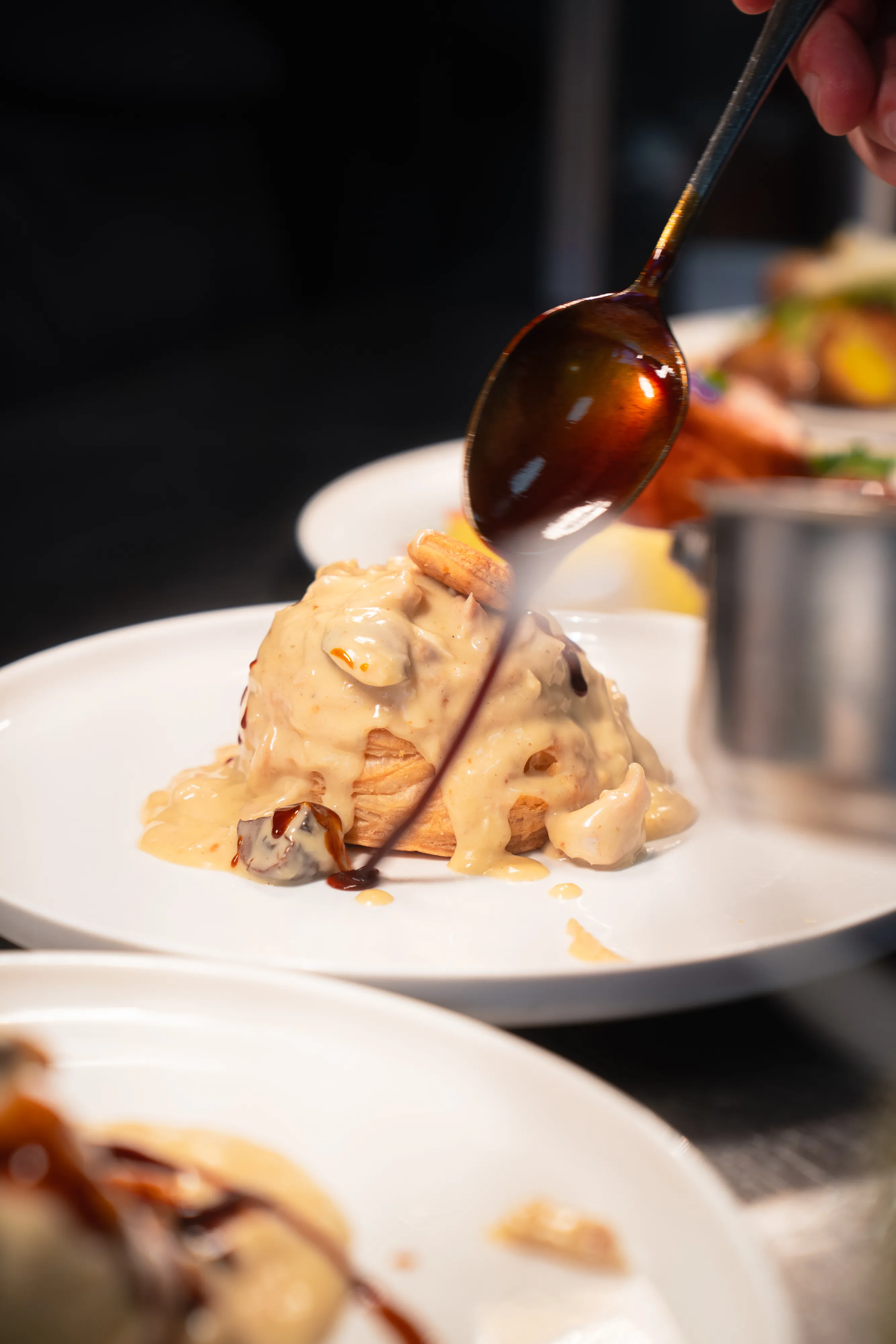 Chef finishing plates with sauce