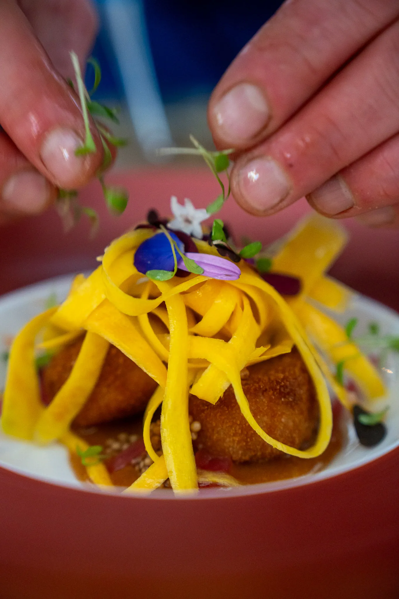 Garnishing croquettes with mango ribbons for a catered event