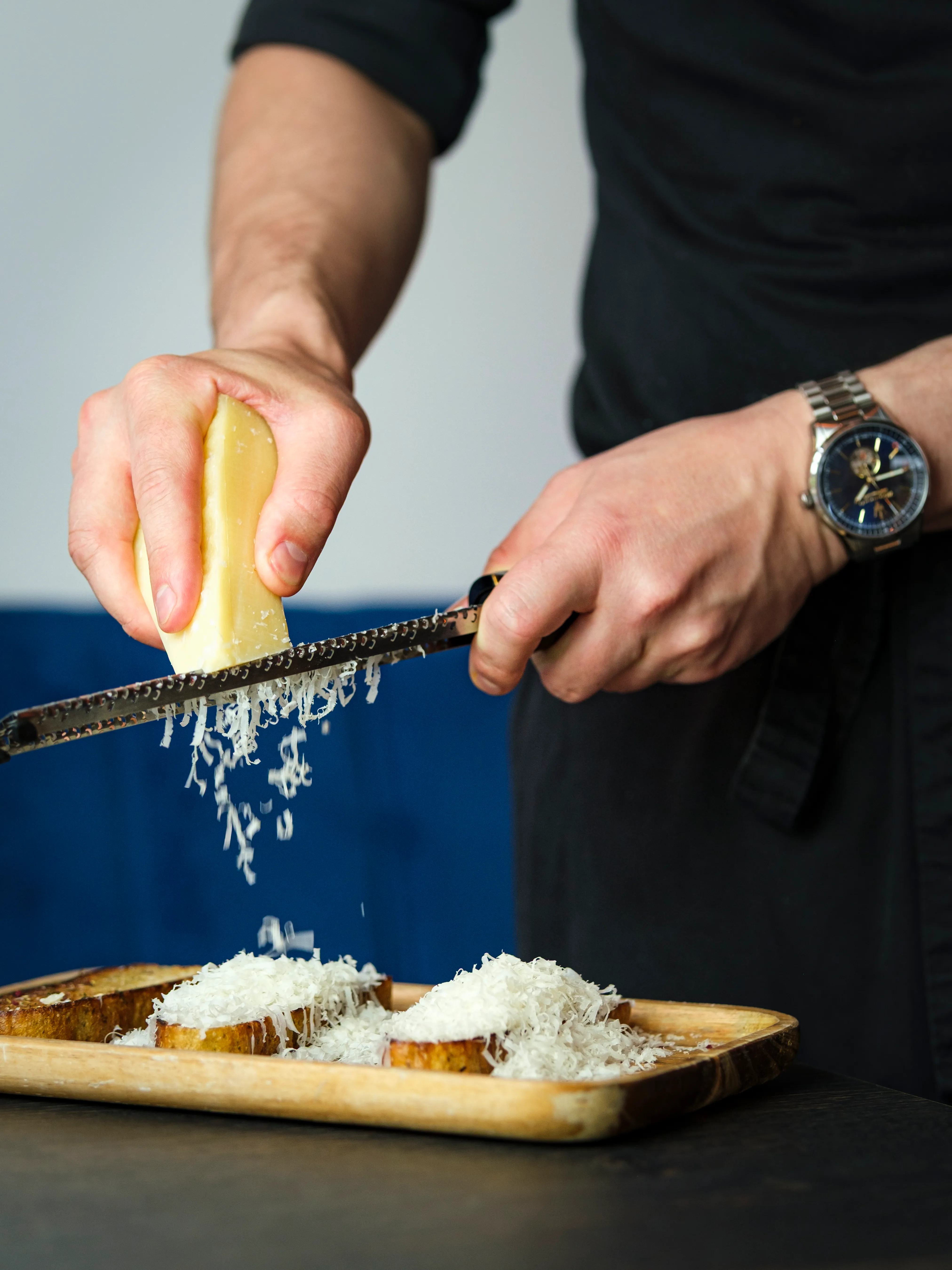 Grating cheese over toasted bread