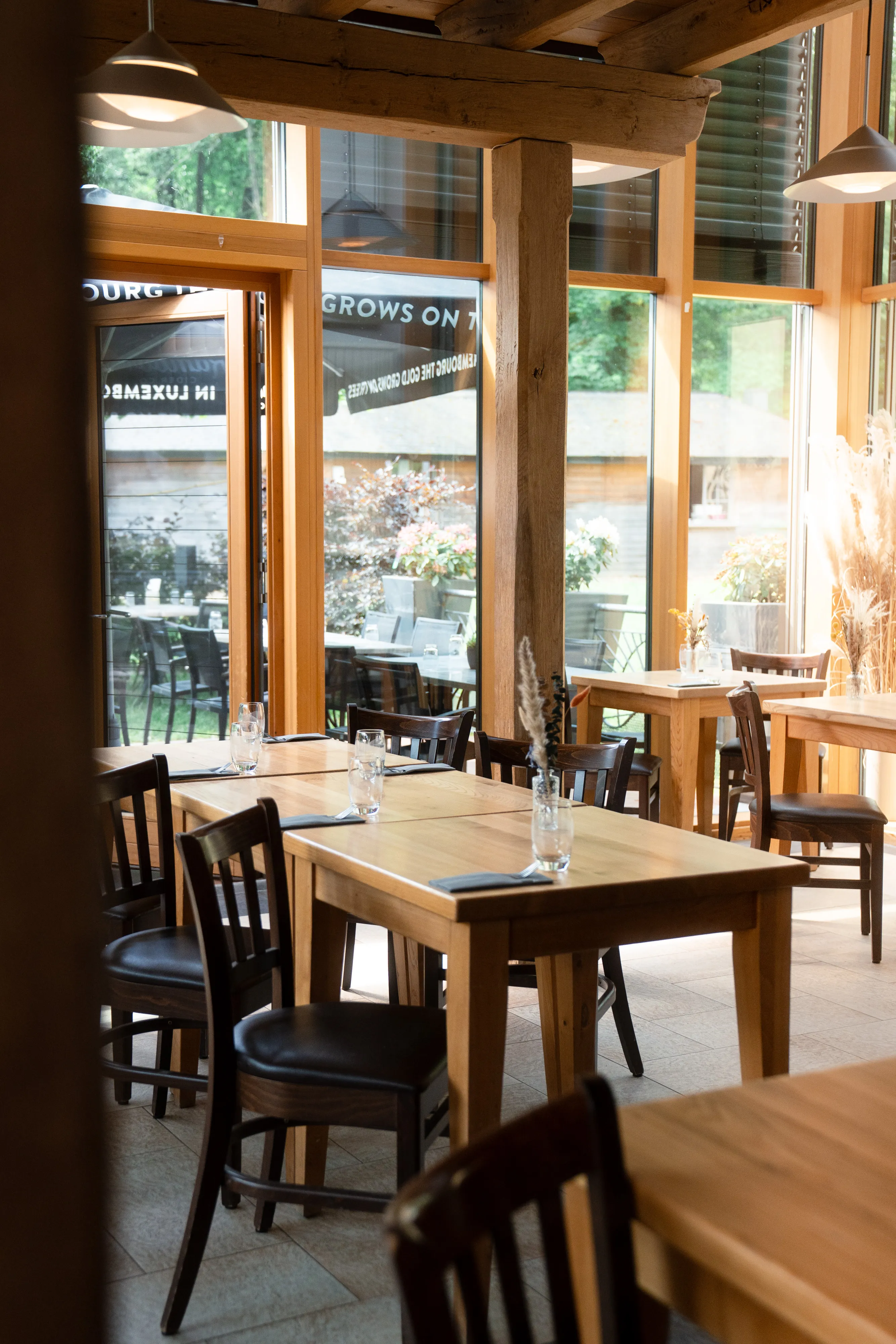 The warm dining room at Restaurant Heringer Millen, with timber beams and garden views