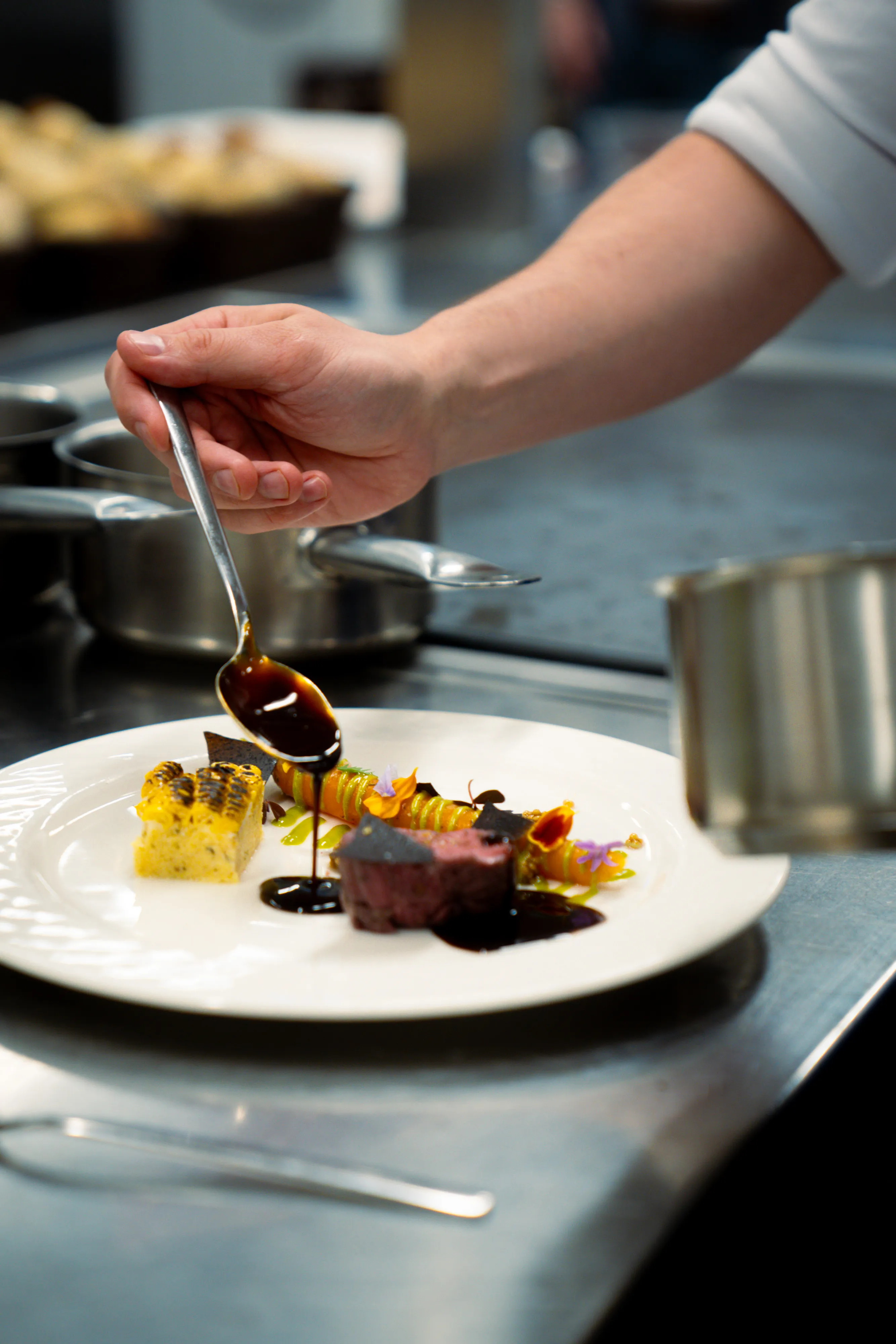 Chef Christophe Prosperi finishing a plate in the kitchen